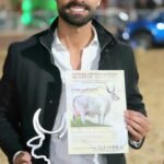 Após 11 anos, Acácia FIV supera recorde na categoria vaca jovem do Guzerá Leiteiro Eros Gazzinelli, da GenBra Agropecuária, segura troféu e certificado em homenagem à vaca Acácia FIV, nova recordista na categoria vaca jovem do Guzerá Leiteiro.